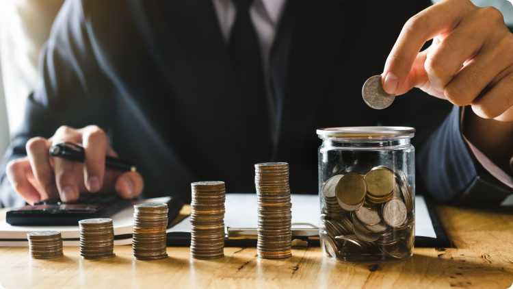 Image showing a jar bank being filled with coins, symbolizing saving money and investing