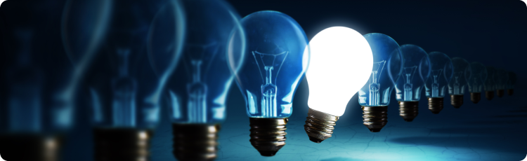 Uma Ãºnica lÃ¢mpada destaca-se no centro de uma fila de lÃ¢mpadas idÃªnticas, indicando uma ideia ou uma soluÃ§Ã£o para resolver problemas