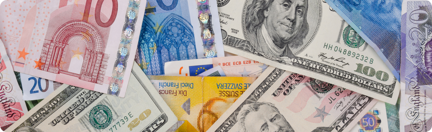 A diverse stack of banknotes featuring various global currencies arranged neatly in a pill