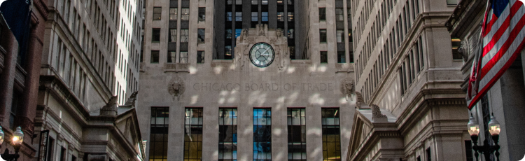 The building of the Chicago Board of Trade featuring a prominent clock on its side, showcasing architectural details and timekeeping functionality