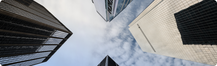 A view from the ground looking up at towering skyscrapers in an urban environment, showcasing their impressive height
