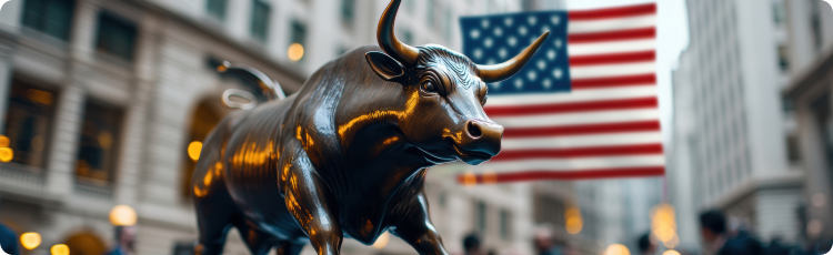 A bull statue stands prominently in front of a building, adorned with an American flag waving in the background