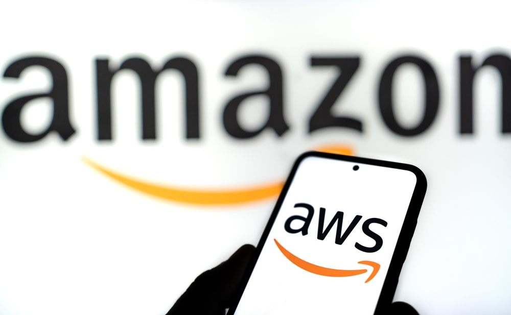 Logo AWS en la pantalla de un telefono con el logo de amazon en el fondo