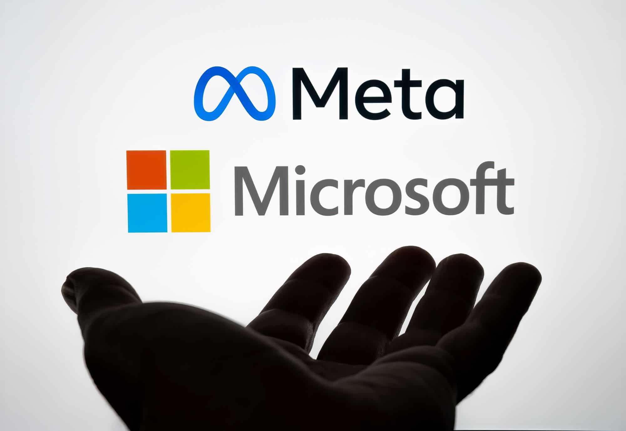 Una mano extendida hacia las logos de microsoft y meta