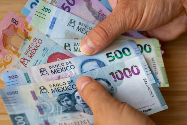 dos manos contando varias notas de peso mexicano