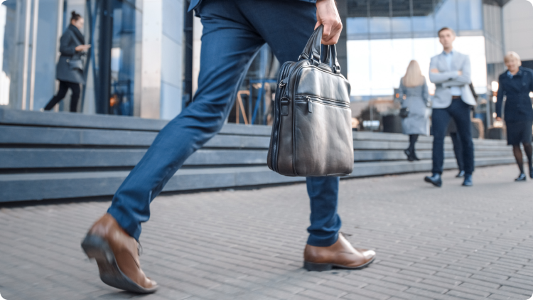 A businessman in a suit and tie walking confidently on a city street.