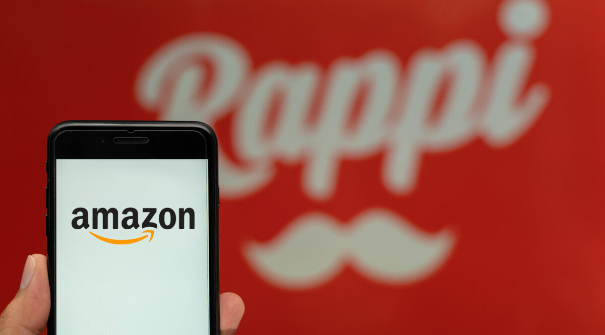 Telefono mostrando la logo de amazon con logo de rappi en el fondo