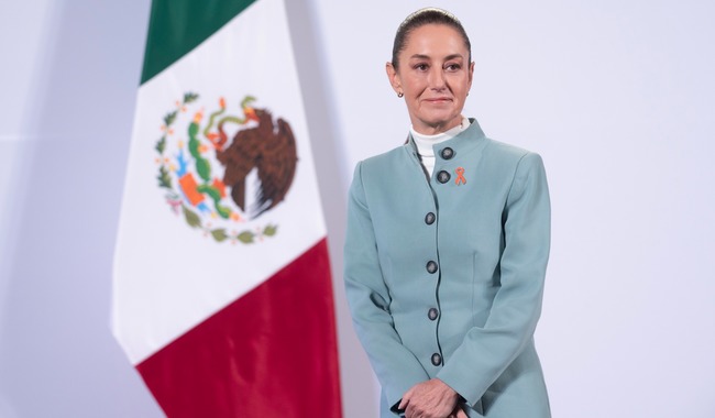Claudia sheinbaum presidente de mexico en frente a la bandera mexicana