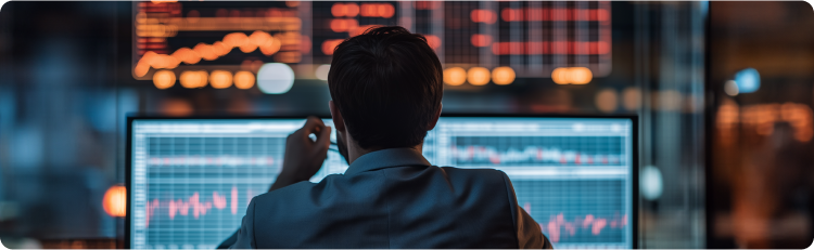 Um homem olha atentamente para um ecrã de computador que exibe gráficos do mercado de ações e análises de dados