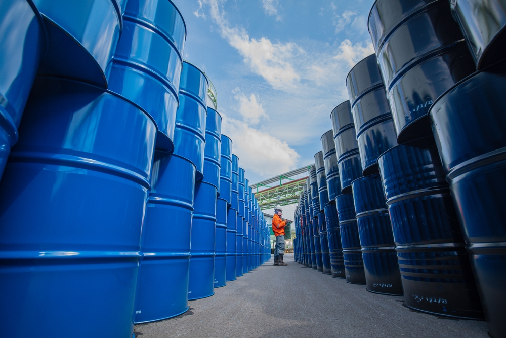 La inspección de los trabajadores masculinos registra barriles de aceite de tambor azul
