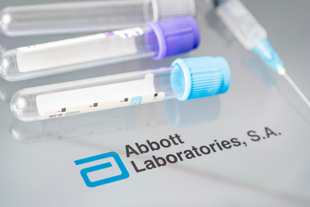 Viales de lÃquido sobre una mesa blanca y el logotipo de Abbott Laboratories