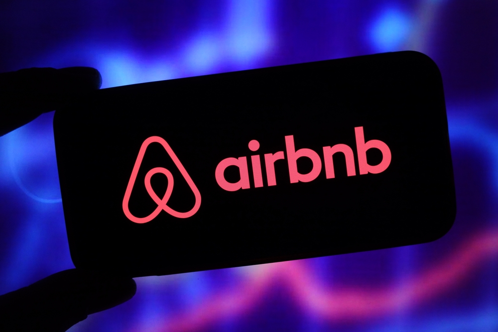  Se muestra el logotipo de la empresa Airbnb en el telÃ©fono mÃ³vil