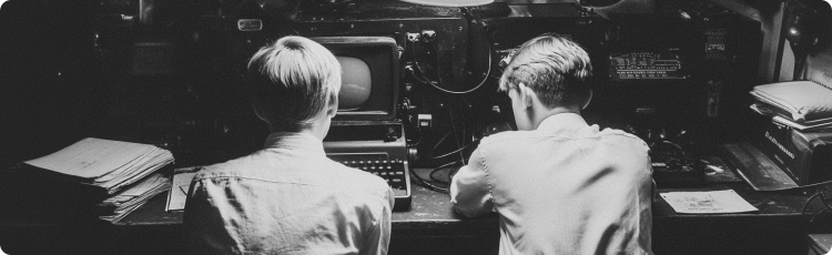 Dois jovens a trabalhar juntos num computador antigo, representando o inÃ­cio da programaÃ§Ã£o e do espÃ­rito empreendedor.