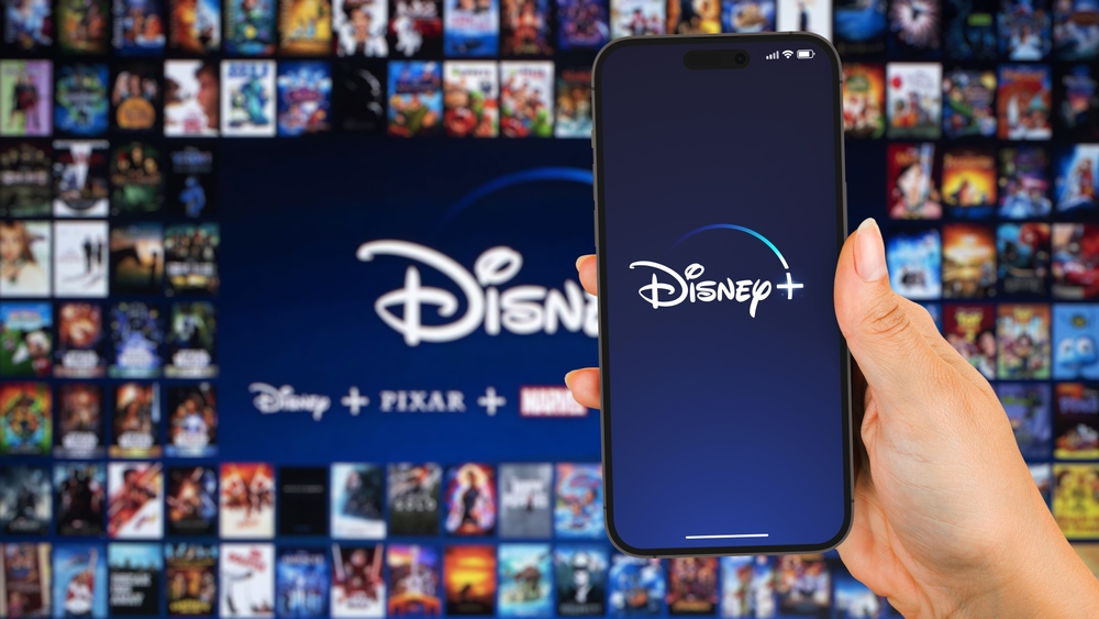 Mano femenina sosteniendo una aplicacion de streaming para iPhone 14 Pro con Disney Plus