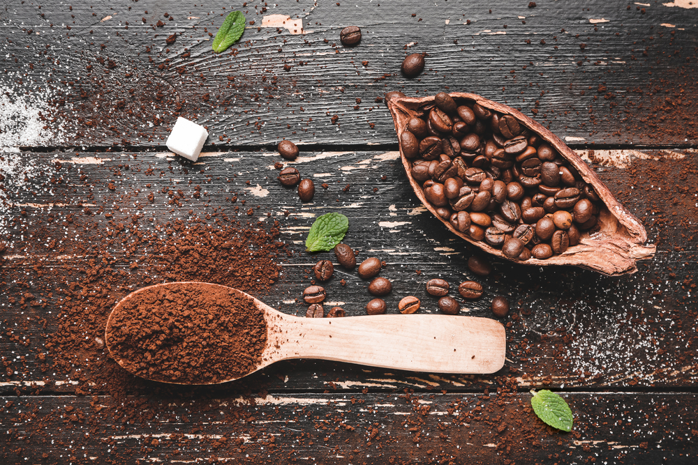 Composicion con granos de cafÃ© y polvo sobre fondo de madera