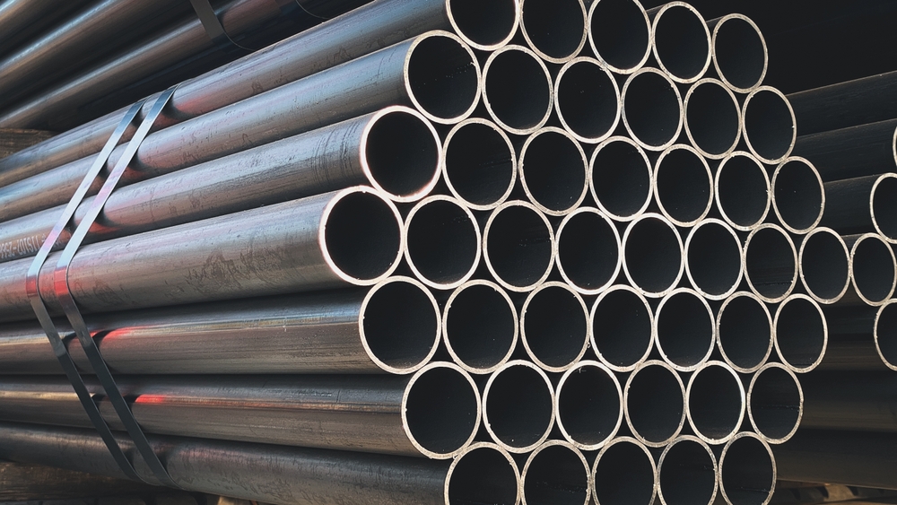 tubos de acero negro en el estante en la yarda de stock de la fabrica