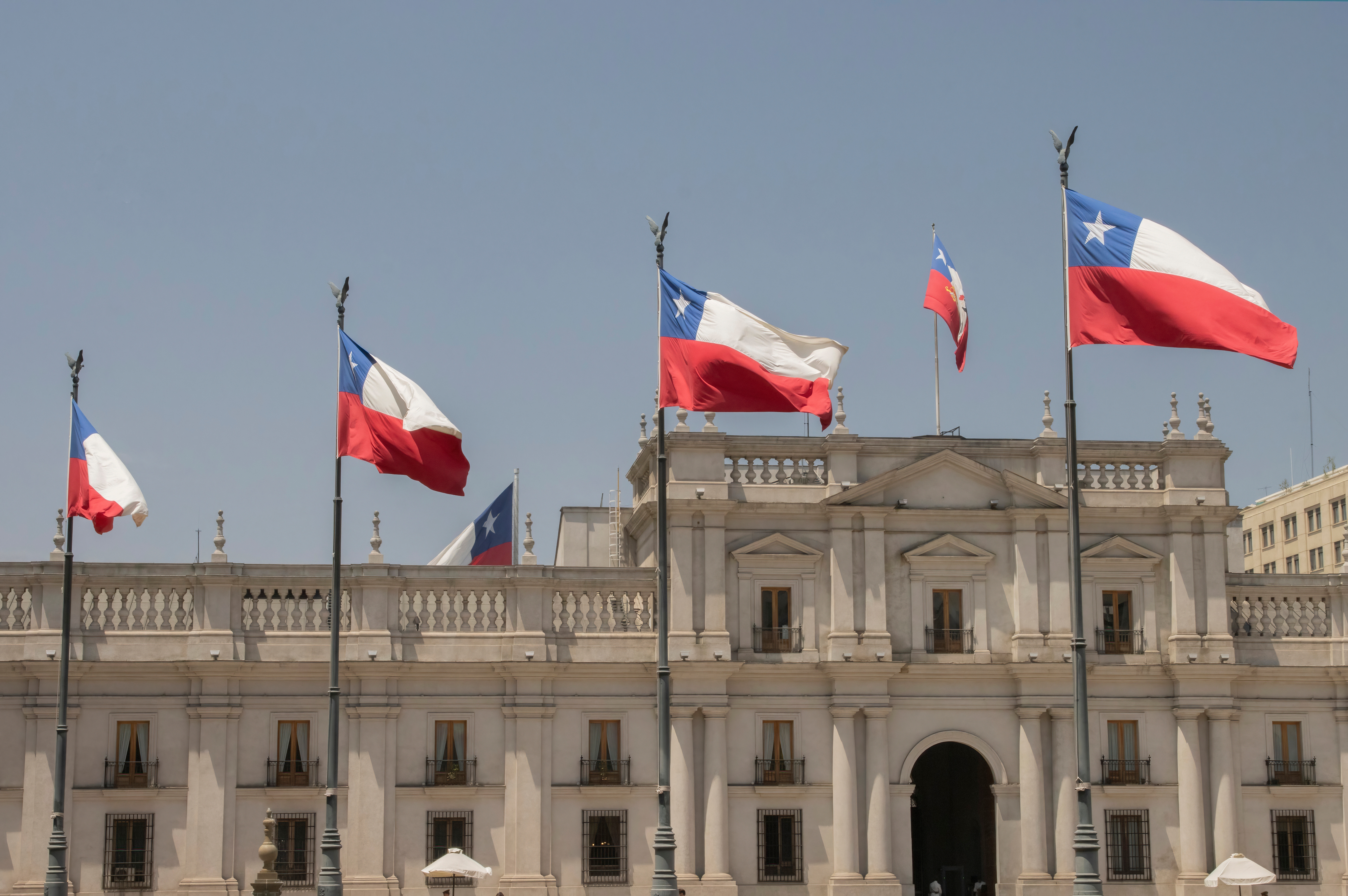 El palacio de la moneda en Chile con banderas en la frente