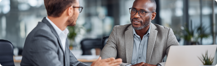 Dois profissionais vestidos com trajes executivos discutindo estratÃ©gias financeiras em um ambiente de escritÃ³rio moderno, simbolizando o planeamento de investimentos e conversas de consultoria sobre aÃ§Ãµes de serviÃ§os pÃºblicos ou gestÃ£o de carteiras.