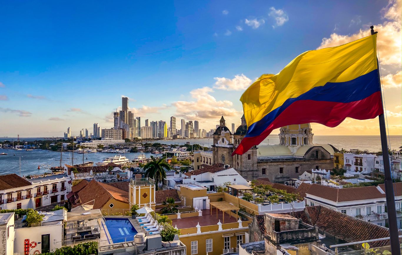 La bandera de Colombia con una de sus ciudades en el fondo