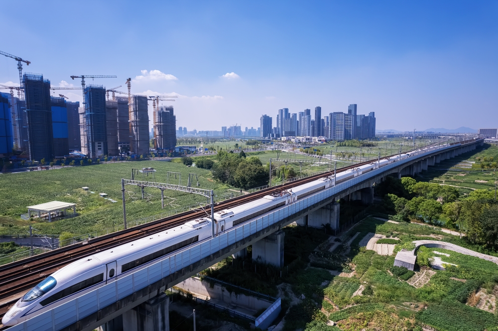 Tren de alta velocidad que planea a través de un paisaje Urbana moderno