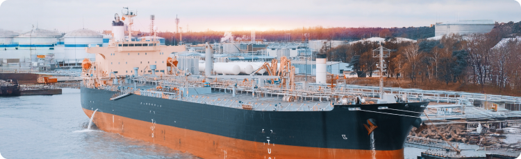 Petroleiro atracado numa refinaria industrial, destacando o papel das frotas de petroleiros e do transporte de energia nos investimentos em aÃ§Ãµes do setor de transporte marÃ­timo.