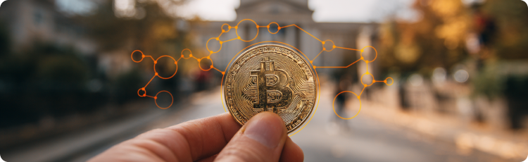 prim-plan cu un bÄrbat care Èine o monedÄ aurie Bitcoin, pe fundal un district financiar blurat, simbolizÃ¢nd deÈinerea unei monede digitale.