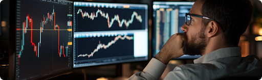  Egy Ã¶ltÃ¶nyÃ¶s fÃ©rfi a kÃ©pernyÅn megjelenÃ­tett tÅzsdei grafikonokat vizsgÃ¡lja, pÃ©nzÃ¼gyi adatok elemzÃ©sÃ©re Ã¶sszpontosÃ­tva.