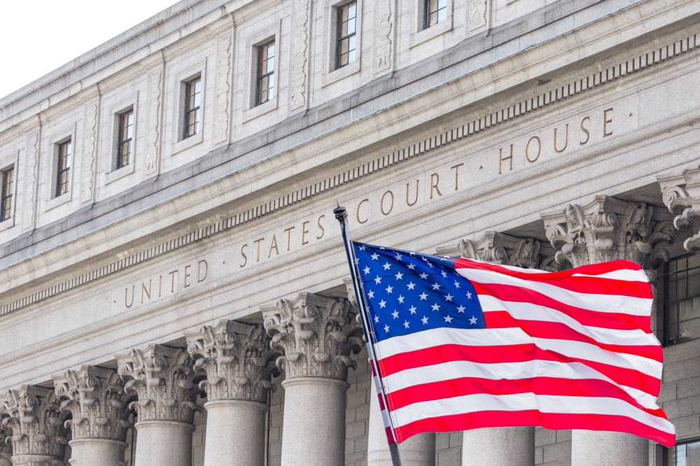 Bandera nacional de Estados Unidos ondeando al viento frente a la Corte de Justicia de Estados Unidos en la Nueva York
