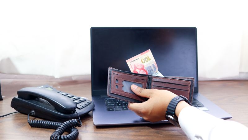 Imagen de una cartera frente a un ordenador en un artÃ­culo sobre cÃ³mo elegir un brÃ³ker para invertir en renta fija como PYME