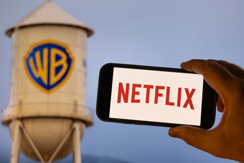 Logo de Netflix en la pantalla de un mÃ³vil visto contra la torre de agua del estudio Warner Bros.