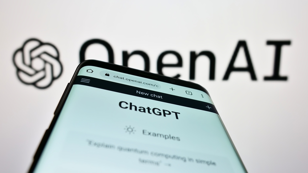 Un telefono con chatgpt abierto y de fondo el logo de open ai