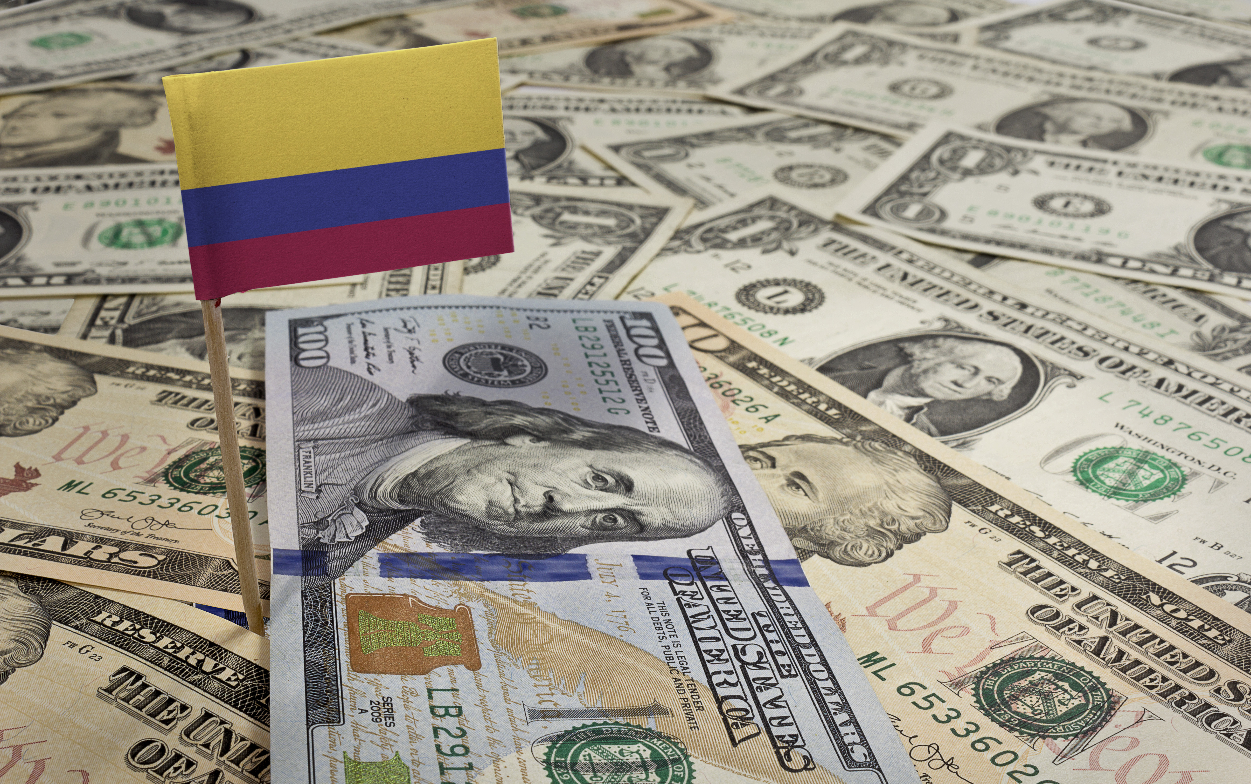 Flag of Colombia sticking in a variety of american banknotes.(series)