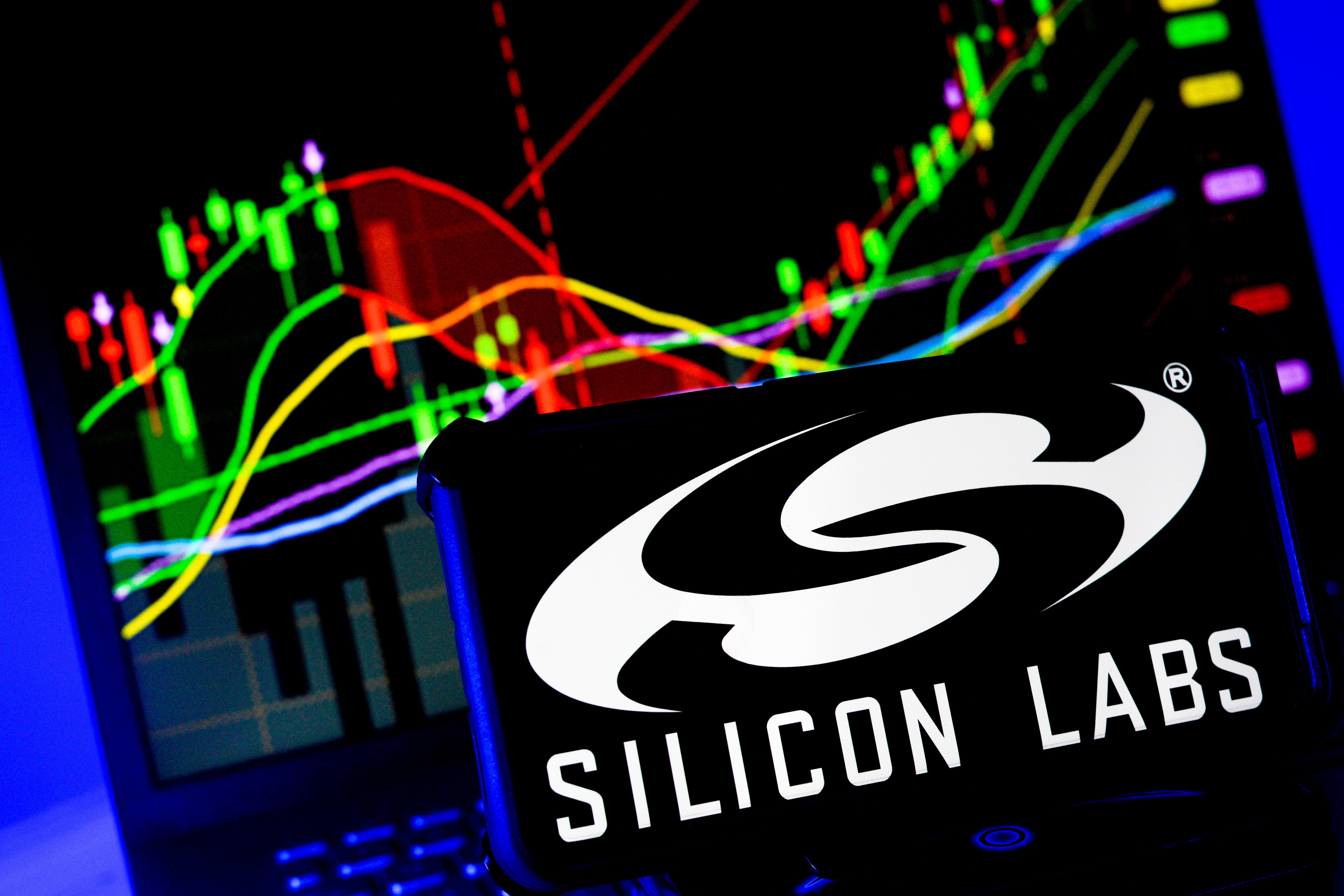 Ada, Ohio - 24 de septiembre de 2025: Logo de la compaÃ±Ã­a Silicon Labs en pantalla con grÃ¡fico de rendimiento financiero de acciones en segundo plano 