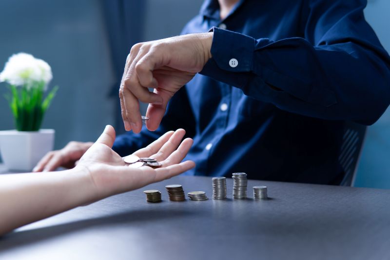 Imagen de una persona dÃ¡ndole dinero a otra en un artÃ­culo sobre cÃ³mo invertir con poco dinero