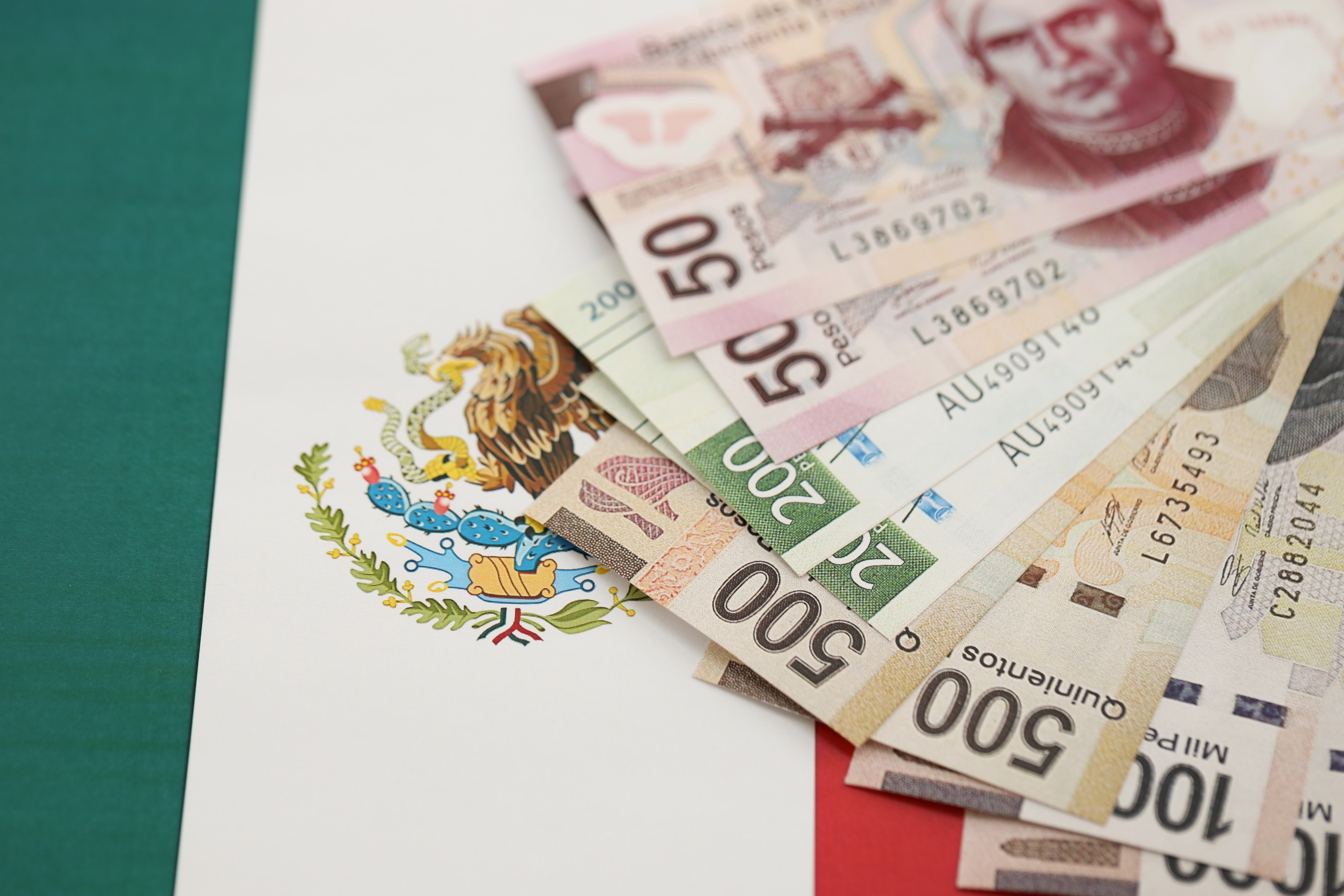 Mexican pesos money bills in big amount lies on Mexico flag close up