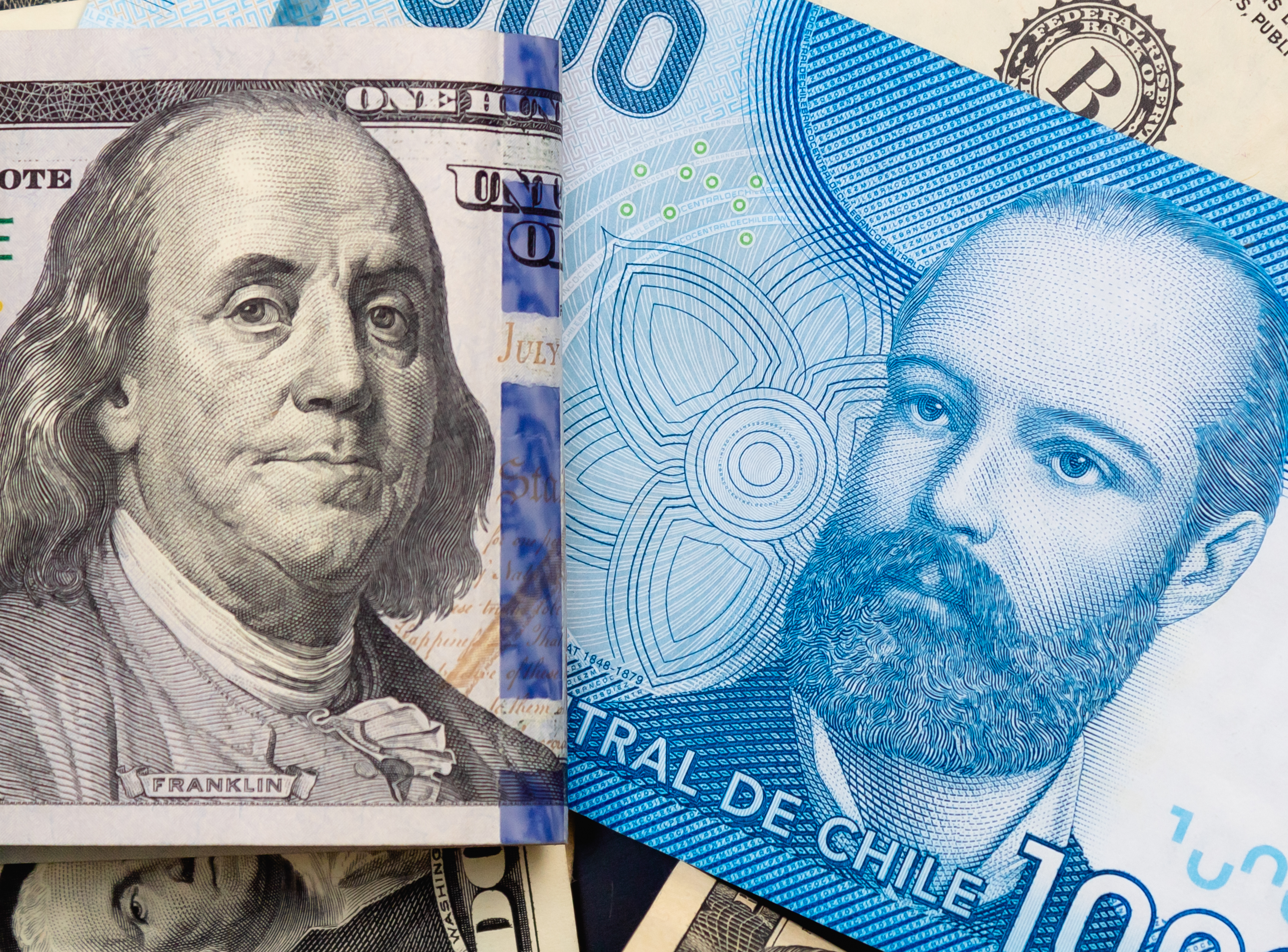 Peso chileno (clp) y DÃ³lar (USD). La cuenta del peso chileno y los billetes de dÃ³lares estadounidenses estÃ¡n de cerca. FotografÃ­a para el concepto de mercado de divisas.