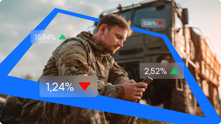 EgyenruhÃ¡s katona Ã¼l egy katonai teherautÃ³ elÅtt, Ã©s okostelefont nÃ©z. KÃ¶rÃ¼lÃ¶tte zÃ¶ld Ã©s piros tÅzsdei szÃ¡zalÃ©kos vÃ¡ltozÃ¡sok lÃ¡thatÃ³k.