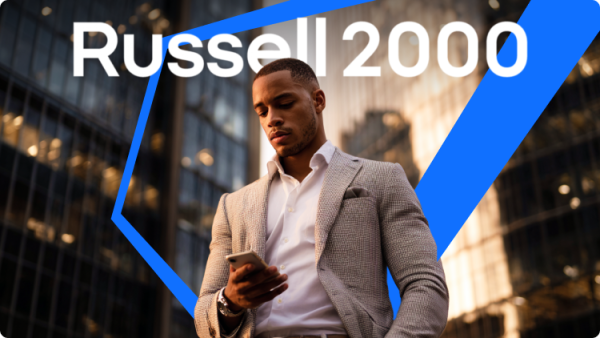 Seorang profesional bisnis memeriksa pembaruan pasar di ponselnya dengan indeks Russell 2000 ditampilkan di latar belakang.
