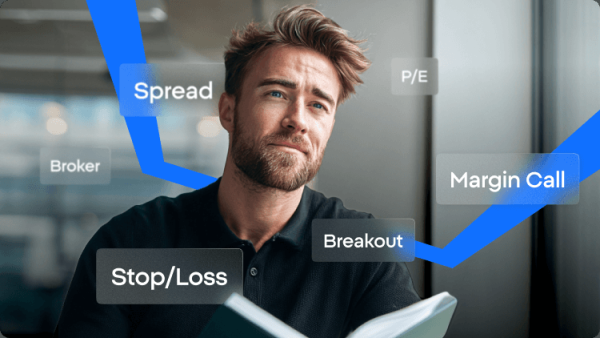 Homem a ler um livro com termos de negociação como spread, margin call, stop loss e breakout exibidos ao seu redor.