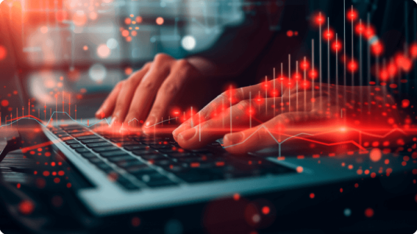 Seseorang fokus mengetik di laptop, dengan garis merah tampak di layar, menggambarkan pekerjaan atau pengeditan yang sedang berlangsun