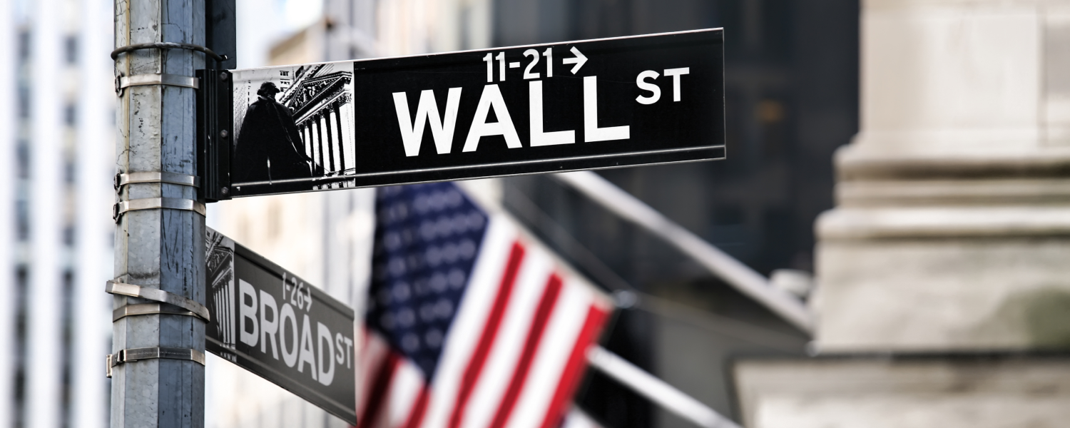 Letrero de Wall Street y bandera americana