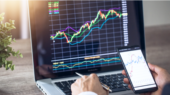 Main d'un homme qui tient unstylo et son tÃ©lÃ©phone oÃ¹ on y voit un graphique