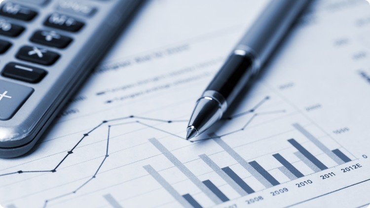  Una penna e una calcolatrice su una carta con grafici e numeri.