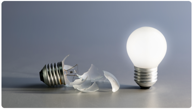 Une image reprÃ©sentant deux ampoules cassÃ©es, montrant du verre brisÃ© et des filaments endommagÃ©s sur un fond neutre