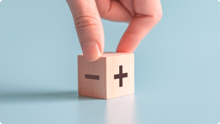 Plus and minus inscriptions on two, wooden cubes.