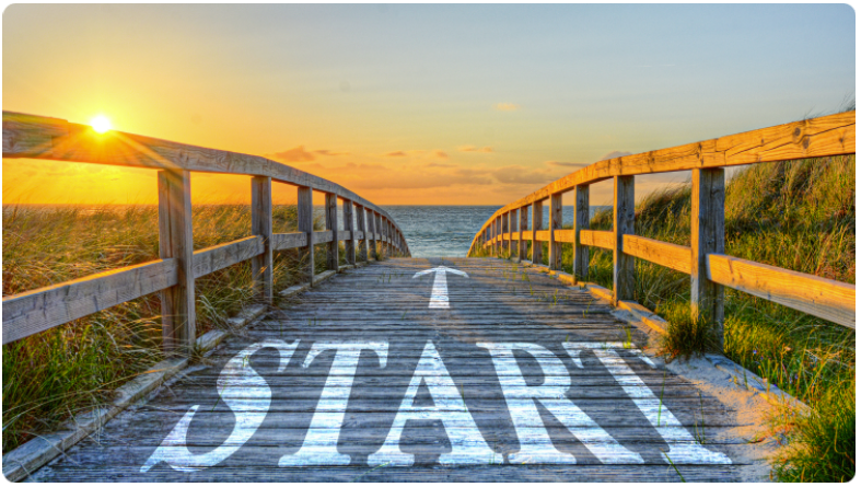 Coucher de soleil au bord de la mer avec un trottoir en bois portant une flÃ¨che blanche et le mot Â« start Â».